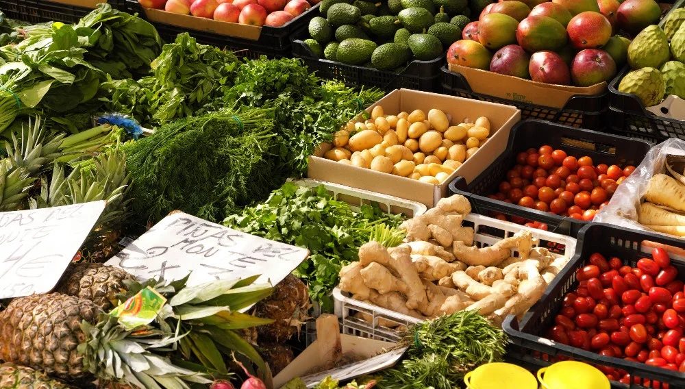 Fresh ginger, herbs, and produce selected to reduce bloating after desi food on display at a market stall.