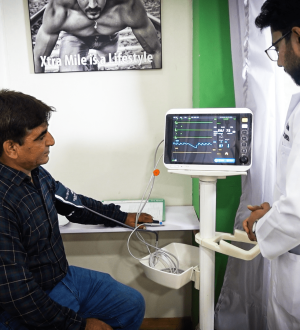 A doctor checking a patient's vitals on a medical monitor at Dr. Ikram's clinic to help treat fatty liver and obesity.