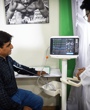 A doctor checking a patient's vitals on a medical monitor at Dr. Ikram's clinic to help treat fatty liver and obesity.