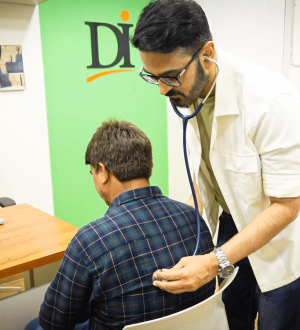 Dr. Ikram using a stethoscope to examine a patient's back at a medical weight loss clinic Karachi, ensuring medical safety.