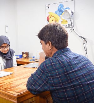 Female doctor in a hijab and a patient discussing treatment options for chronic back pain during a professional medical consultation at Dr. Ikram’s clinic.