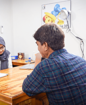 Female doctor in a hijab and a patient discussing treatment options for chronic back pain during a professional medical consultation at Dr. Ikram’s clinic.