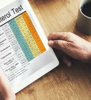Patient reviewing a digital blood cholesterol test report showing LDL and triglyceride levels before starting a high cholesterol diet plan in Pakistan.