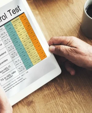 Patient reviewing a digital blood cholesterol test report showing LDL and triglyceride levels before starting a high cholesterol diet plan in Pakistan.