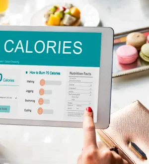 A person using a digital tablet to track metabolic eating vs calorie counting Karachi for fat loss.