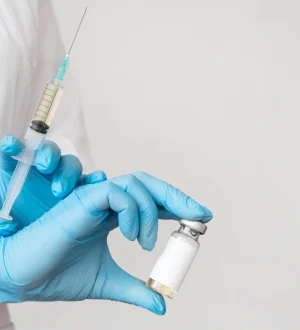 Medical professional wearing blue gloves holding a syringe and medication vial for Mounjaro tirzepatide weight loss treatment in Pakistan.