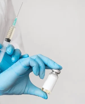 Medical professional wearing blue gloves holding a syringe and medication vial for Mounjaro tirzepatide weight loss treatment in Pakistan.