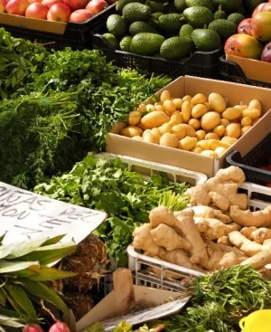 Fresh ginger, herbs, and produce selected to reduce bloating after desi food on display at a market stall.