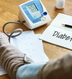 Patient monitoring health stats alongside a 'Diabetes' notebook to plan the best diet for diabetic patients in Pakistan.