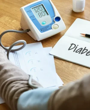 Patient monitoring health stats alongside a 'Diabetes' notebook to plan the best diet for diabetic patients in Pakistan.