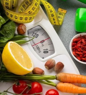 A comprehensive display of healthy foods, green dumbbells, a measuring tape, and a scale, representing the core pillars of metabolic health and weight loss.
